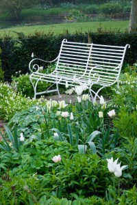 wrought iron bench in white garden